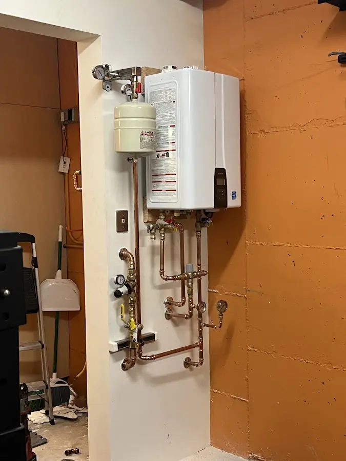 Plumbing technician inspecting water heater connections in Sturgeon Bay